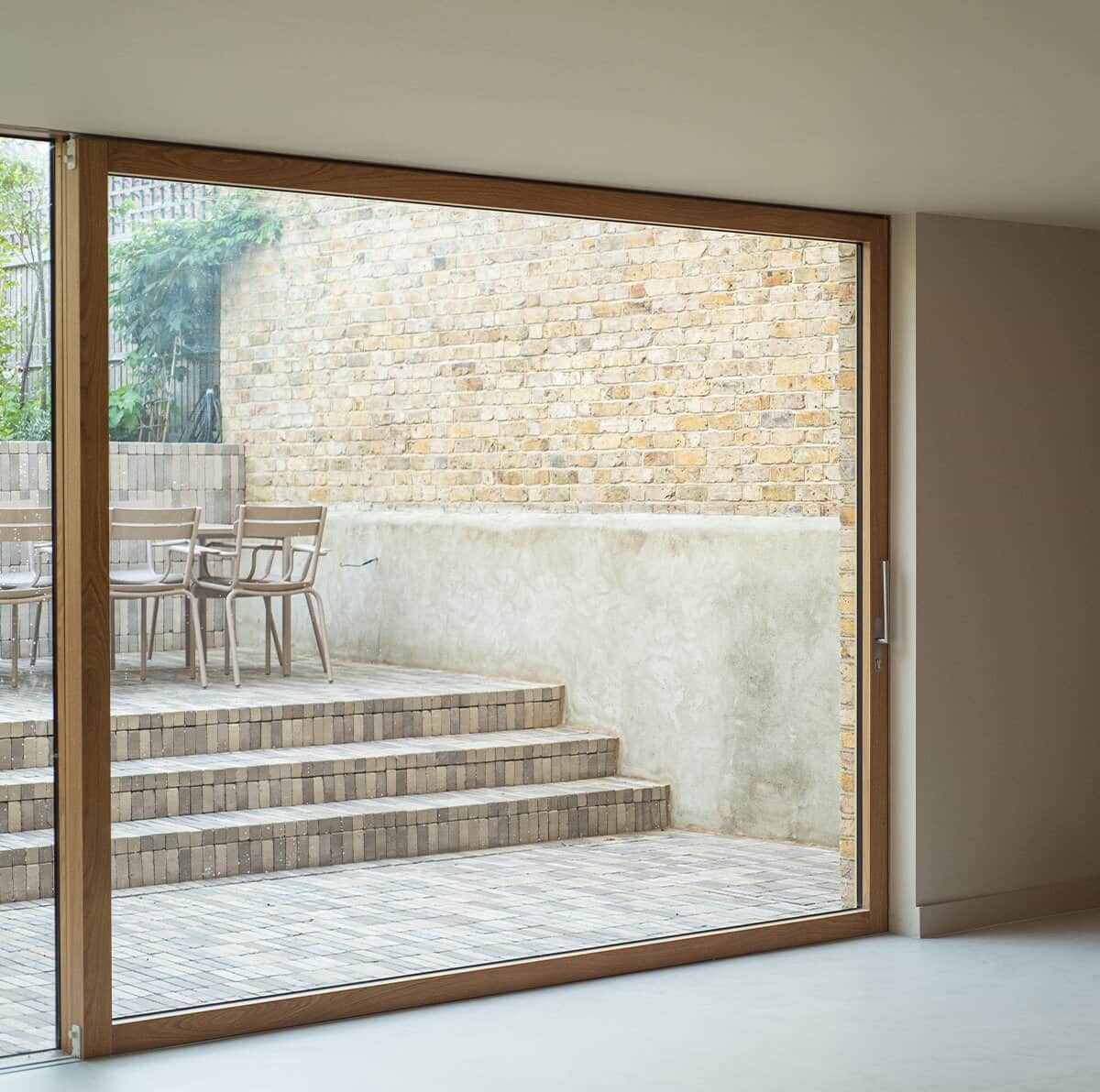 Modern timber sliding door framing the courtyard at Still Frame